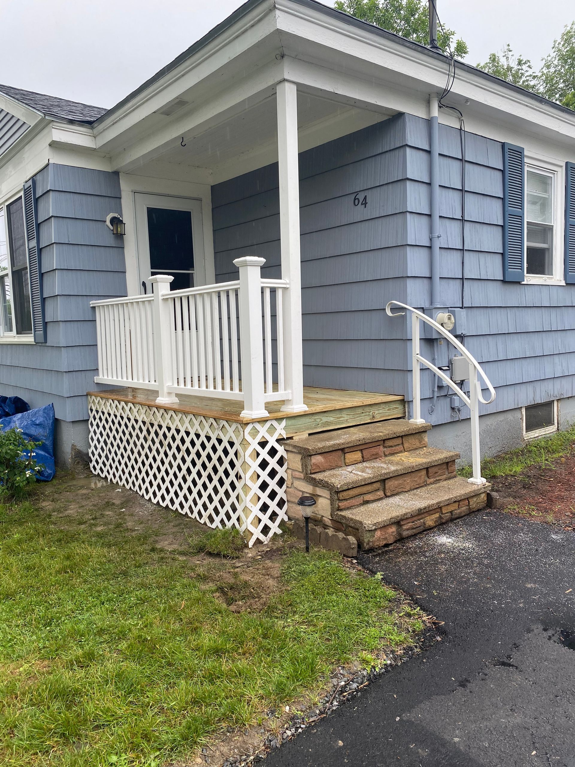 A blue house with a white porch and stairs