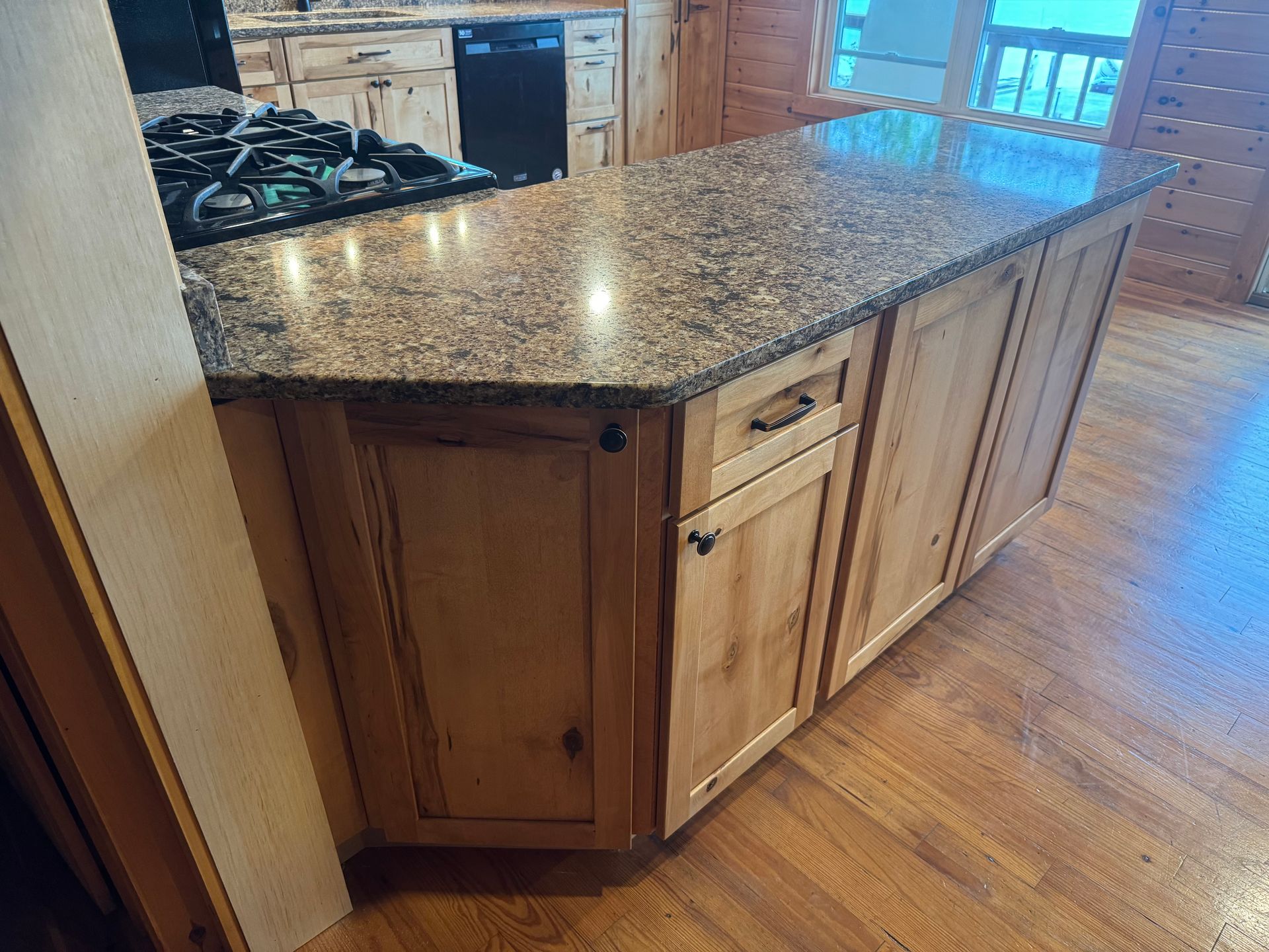 A kitchen with granite counter tops and wooden cabinets.