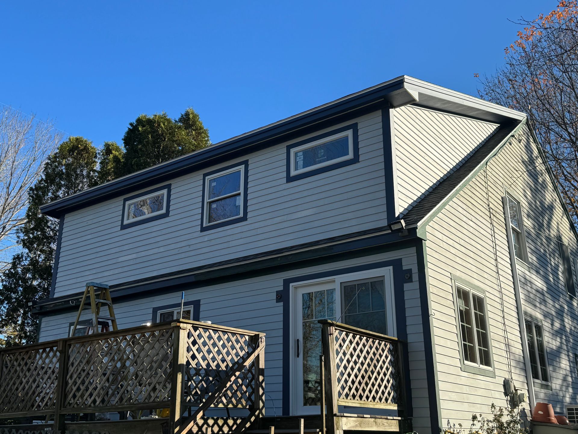a newly built and remodeled house with a ladder on the side of it