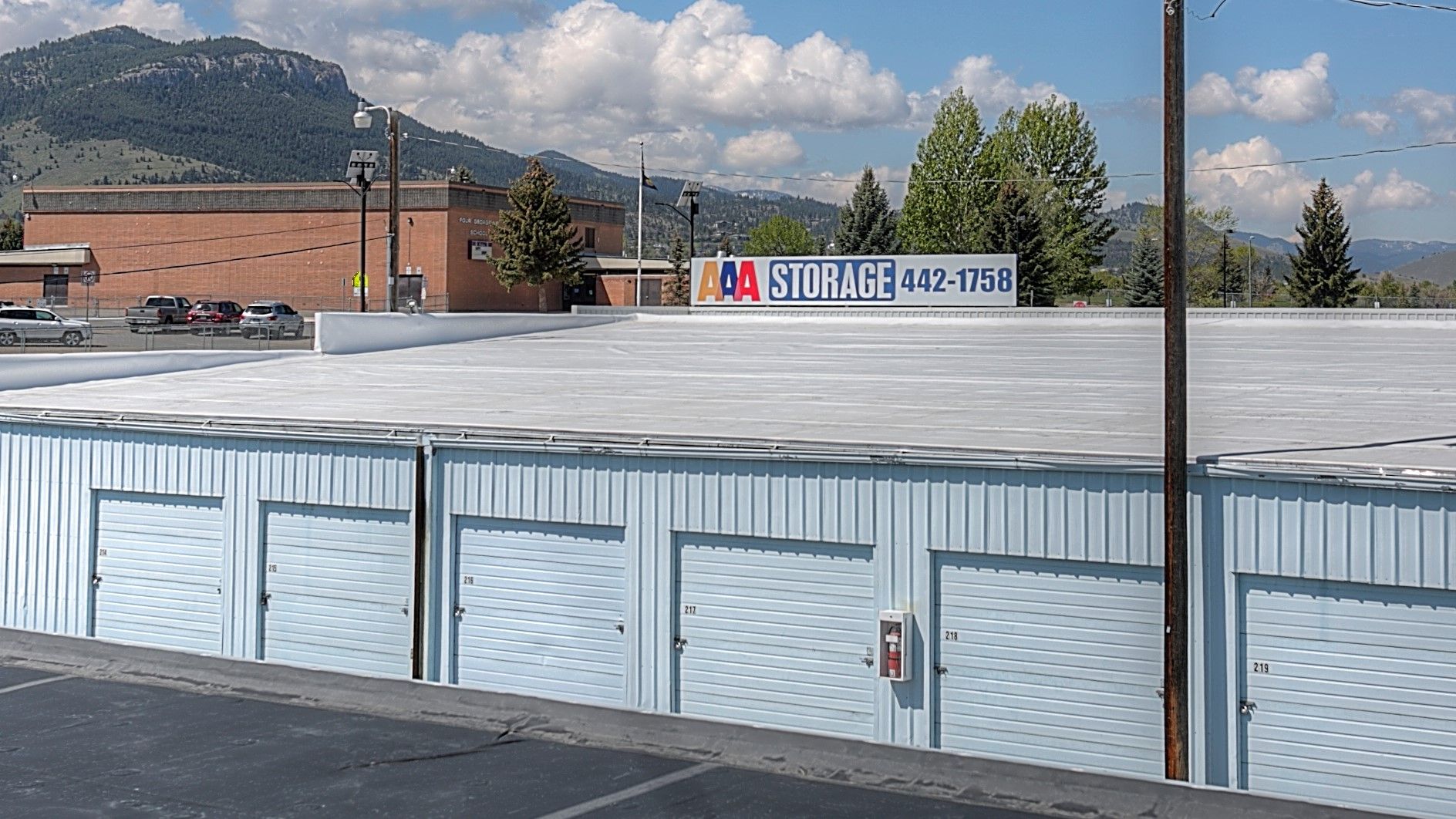 Storage units lining a paved alley under a blue sky