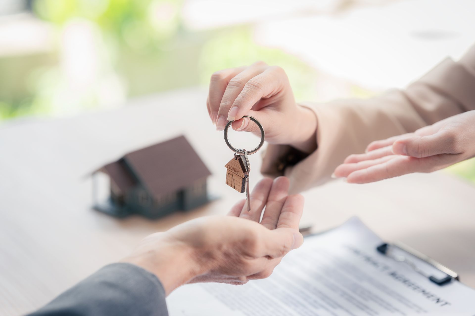 Real estate signing with keys handed over above contract during home purchase closing process today.
