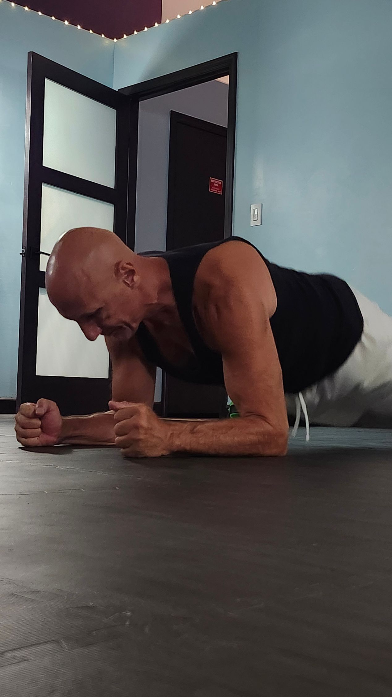 Yoga instructor guides students in a studio; poses include side bends.