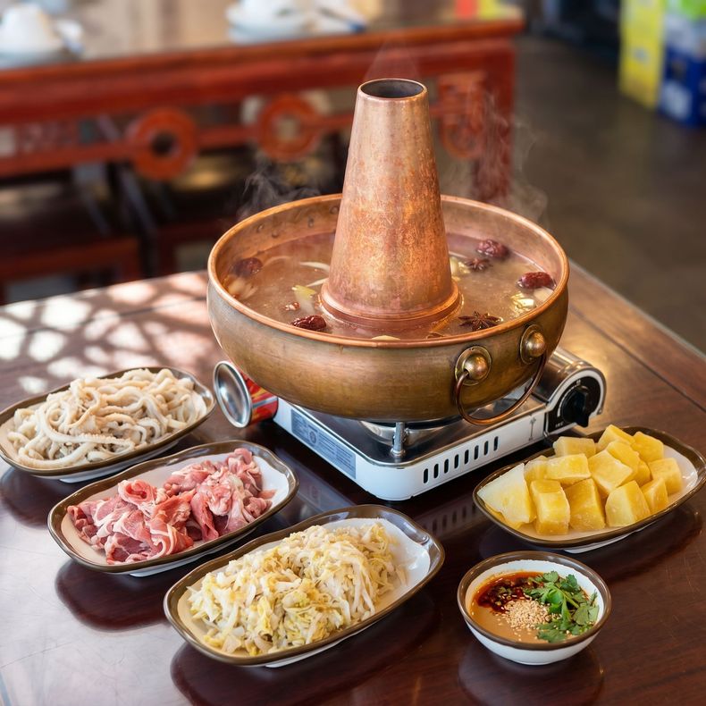Korean hot pot with assorted raw ingredients and side dishes on a restaurant table