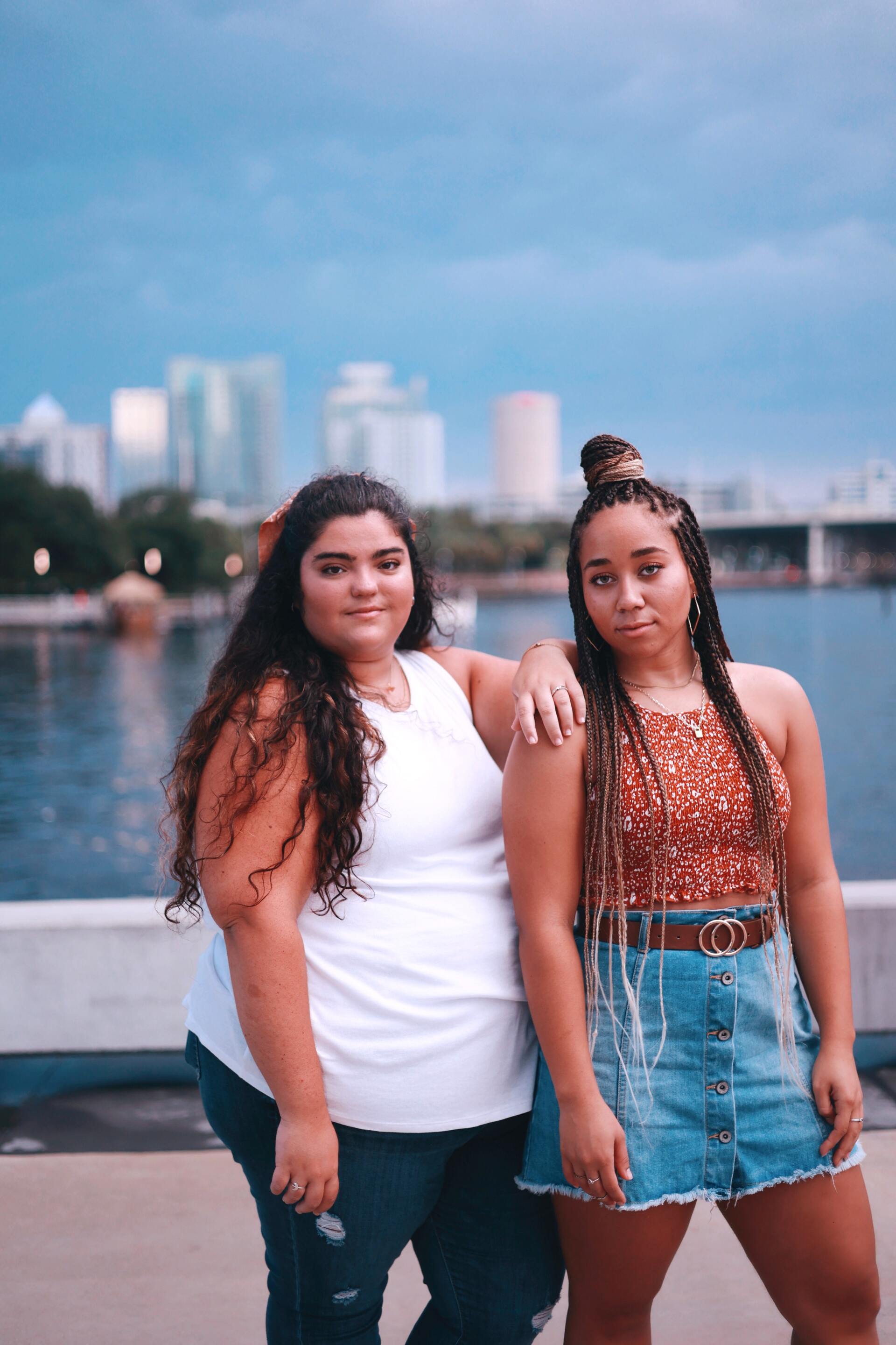 Photo by Tori Conte from Pexels Two women are standing next to each other in front of a body of water.