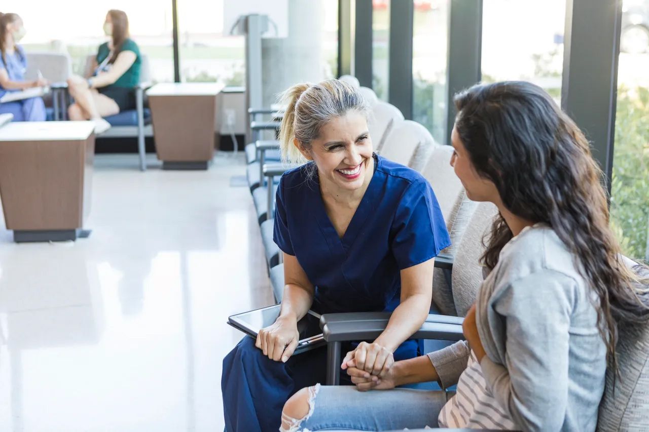 Two women talking in a bright waiting area