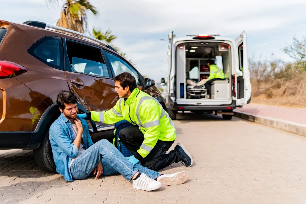 Car accident scene with a responder helping an injured person