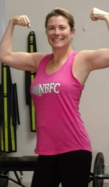 A woman wearing a pink tank top that says nbfc on it