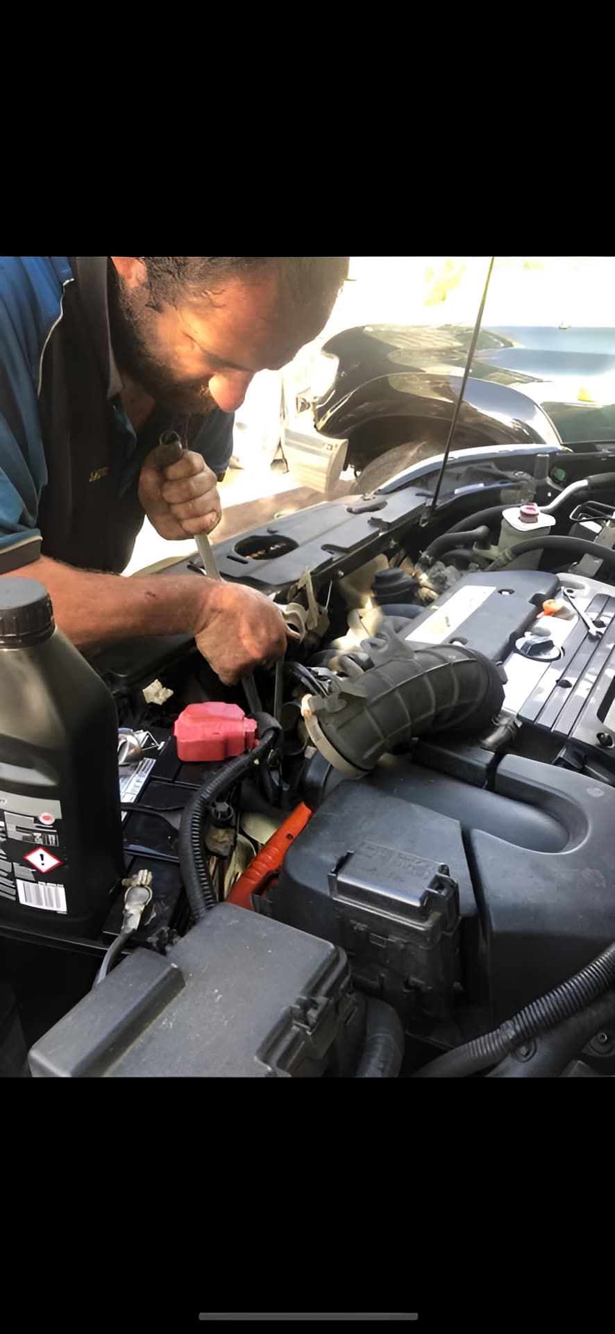 A Man Is Working On The Engine Of A Car — J & T Mobile Mechanics In Highworth, QLD