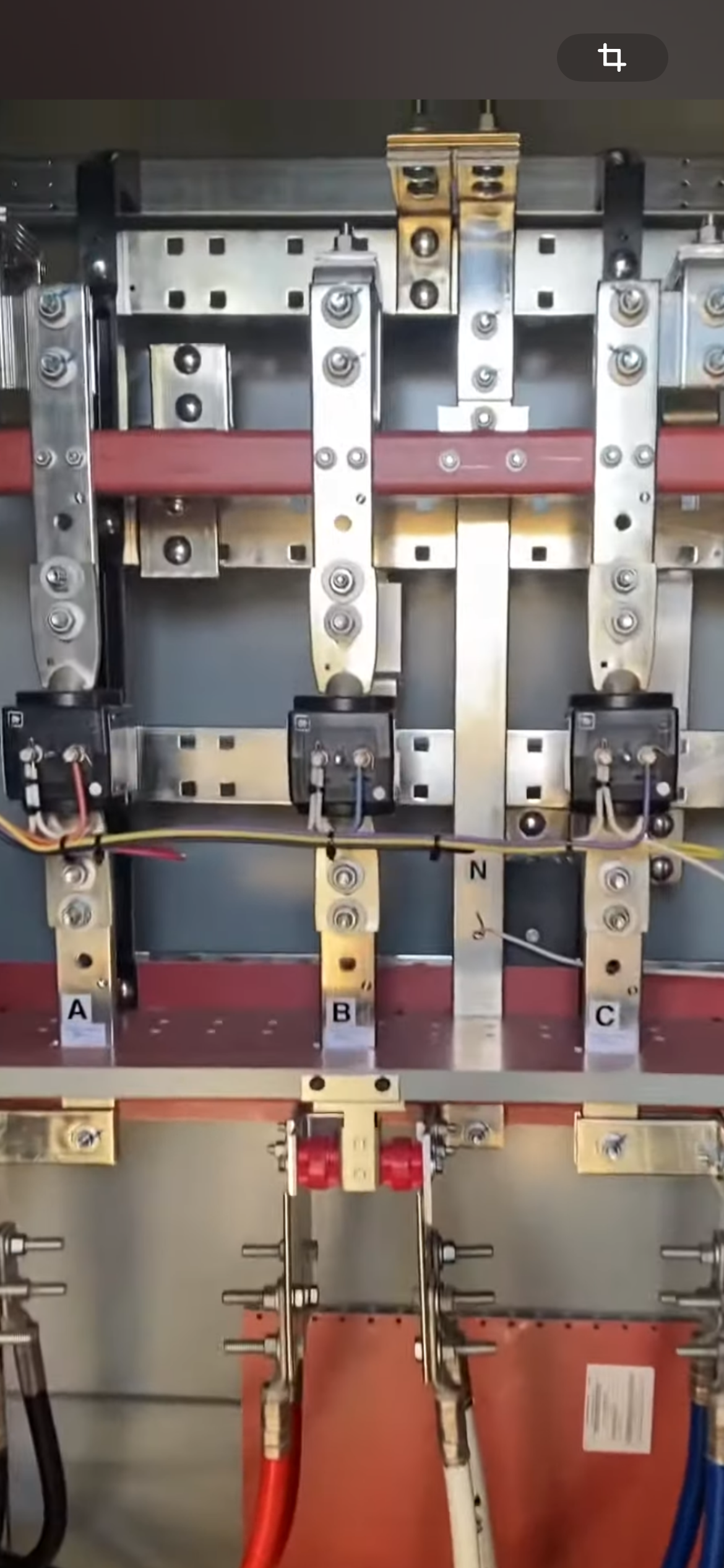 Electrical panel with metallic components, red and white wires, labeled A, B, and C.