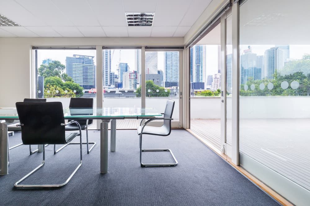 A Conference Room With a Glass Table and Chairs — A1 Maintenance and Building In Old Bar, NSW