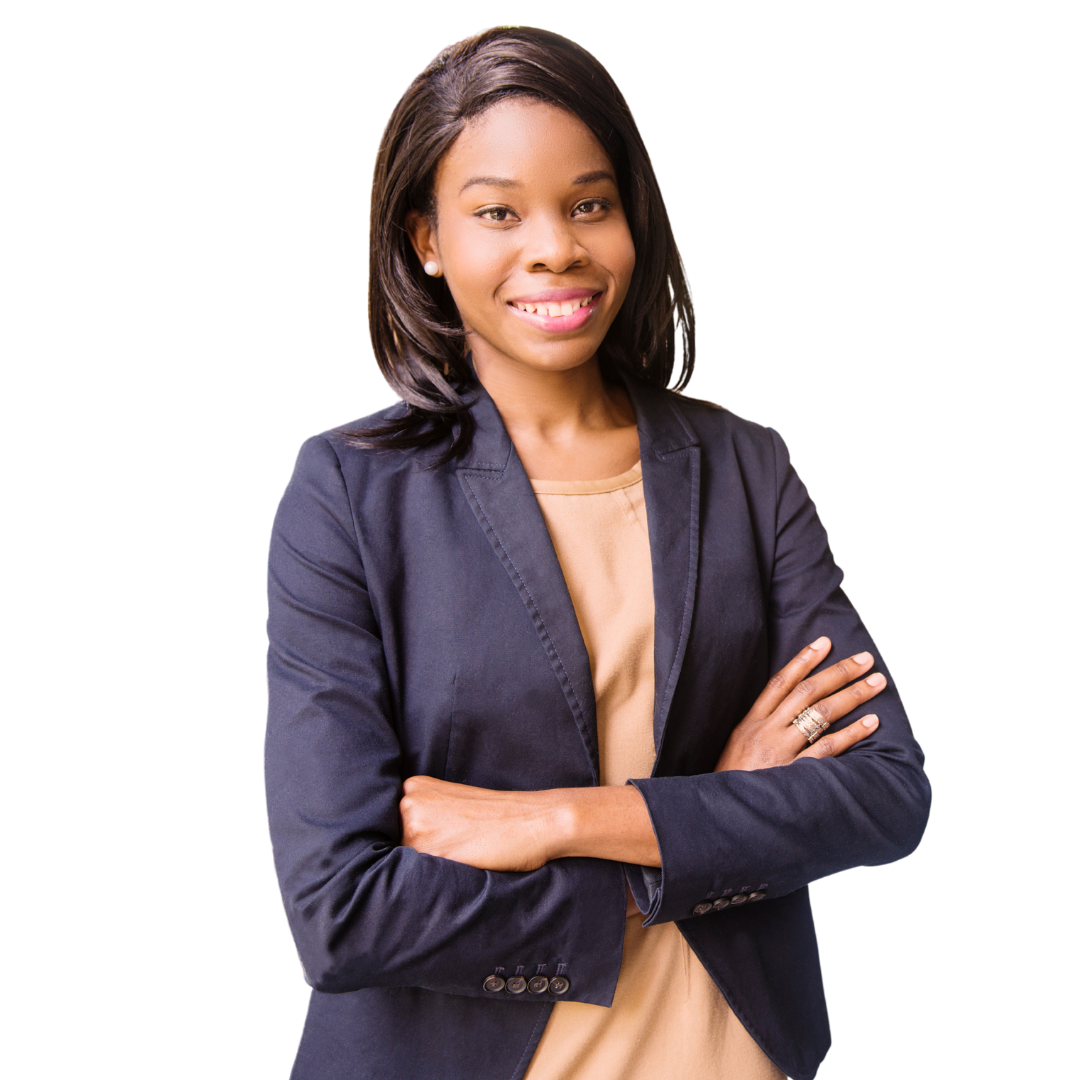 A woman in a business suit is standing with her arms crossed and smiling