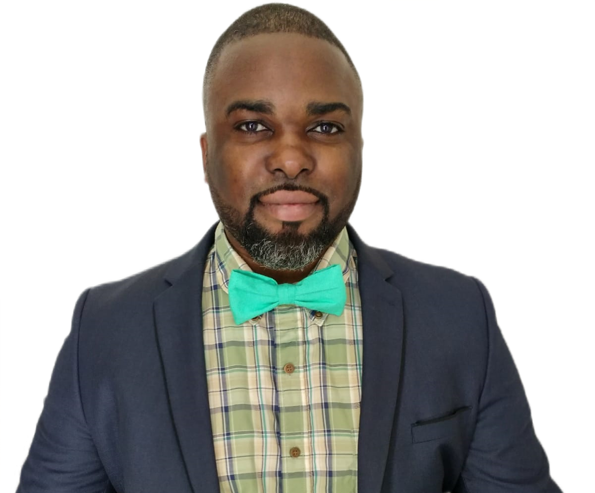A man wearing a suit and a green bow tie