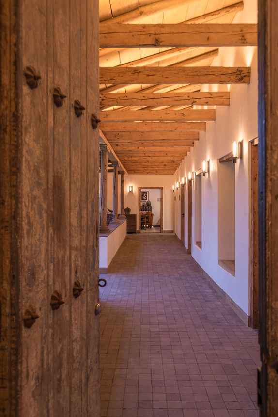 Entrada a La Casa Rodavento, pasillo iluminado con luz natural y techo con vitas de madera. Casa tradicional mexicana