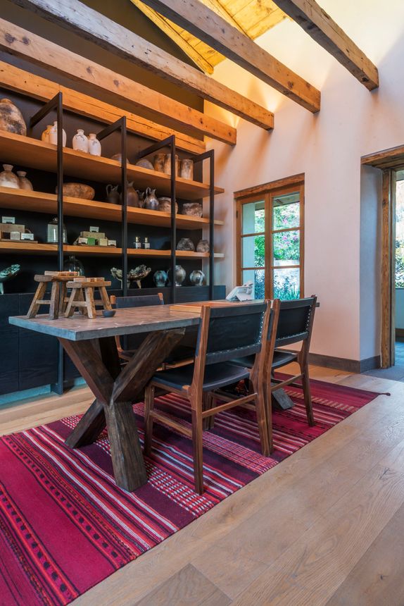 Recepción de La Casa Rodavento con tapetes coloridos y techo con vigas de madrea y mucha luz.