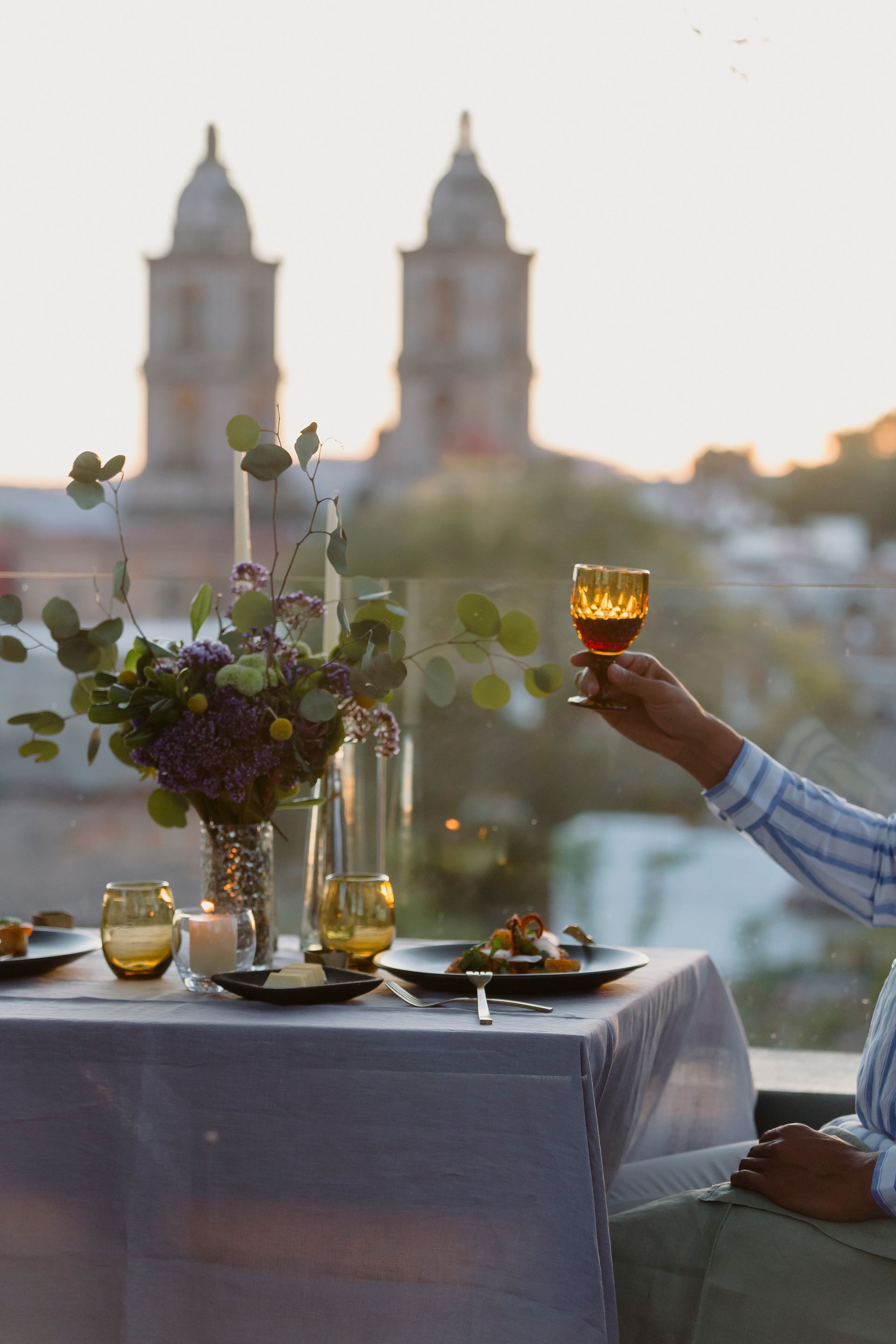 Cena romántica privada con vista a la catedral de valle de bravo. Mesa, copas, flores y brindis.