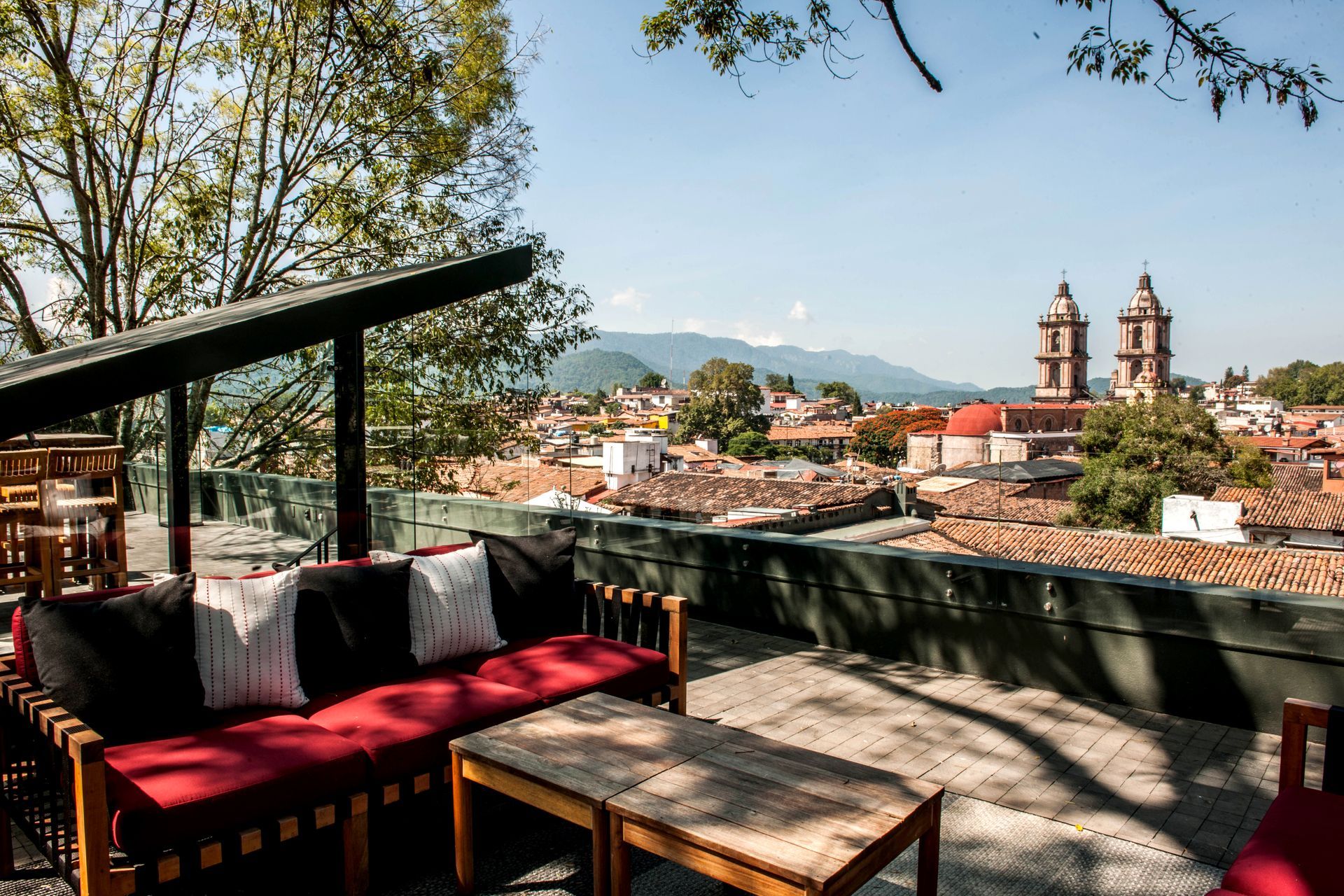 Rooftop de La Casa Rodavento con salas  exteriores color rojo y vista a la catedral y al centro de Valle de Bravo