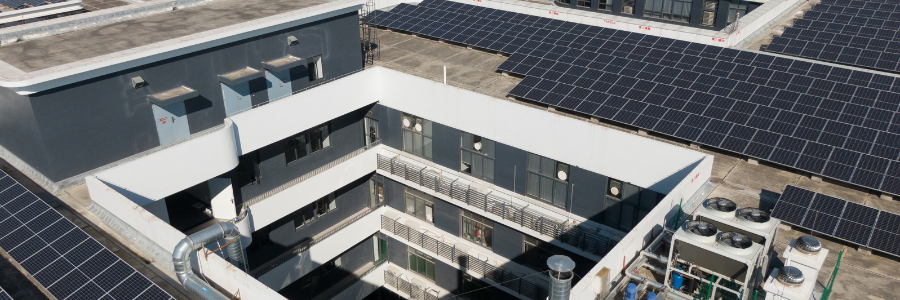An aerial view of a building with solar panels on the roof.