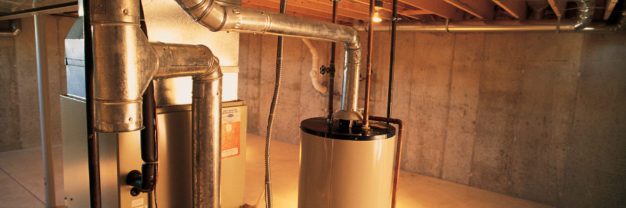 A water heater is hanging from the ceiling in a basement.