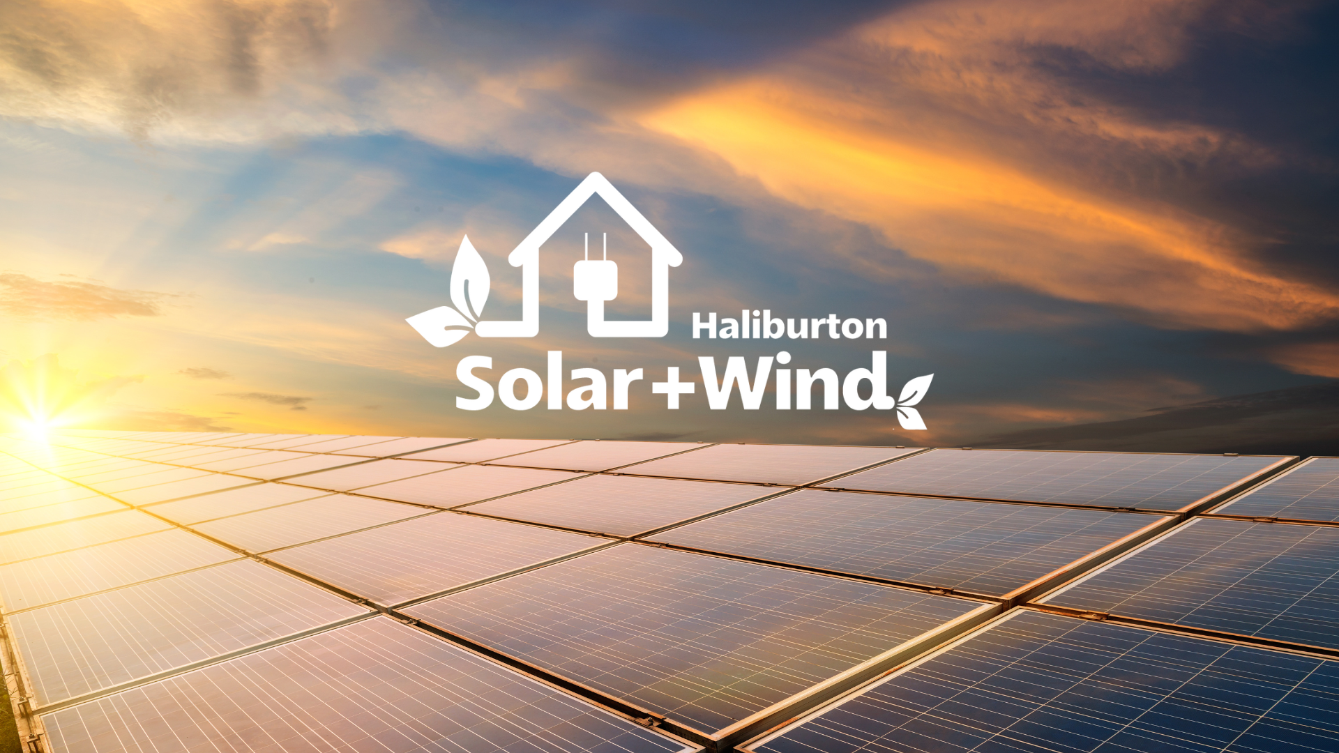 The sun is shining through the clouds over a field of solar panels.