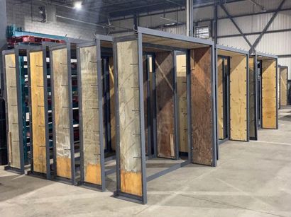 Un entrepôt rempli de nombreuses caisses en bois et de cadres en métal.