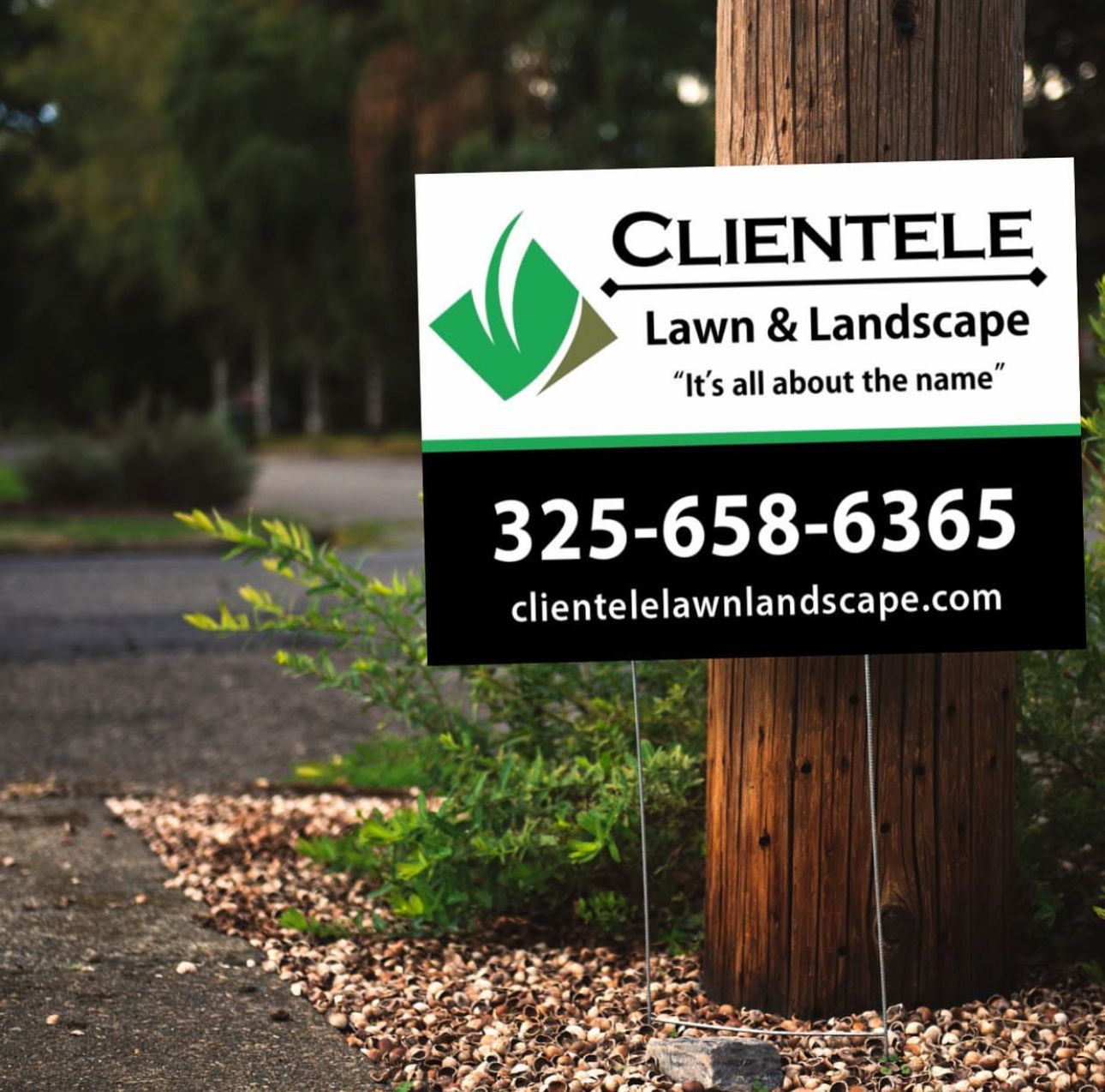 Clientele Lawn & Landscape sign on a wooden pole: black and white with green logo and contact info.
