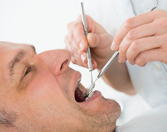 A man is getting his teeth examined by a dentist.