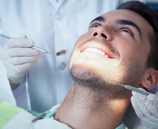A man is getting his teeth examined by a dentist.
