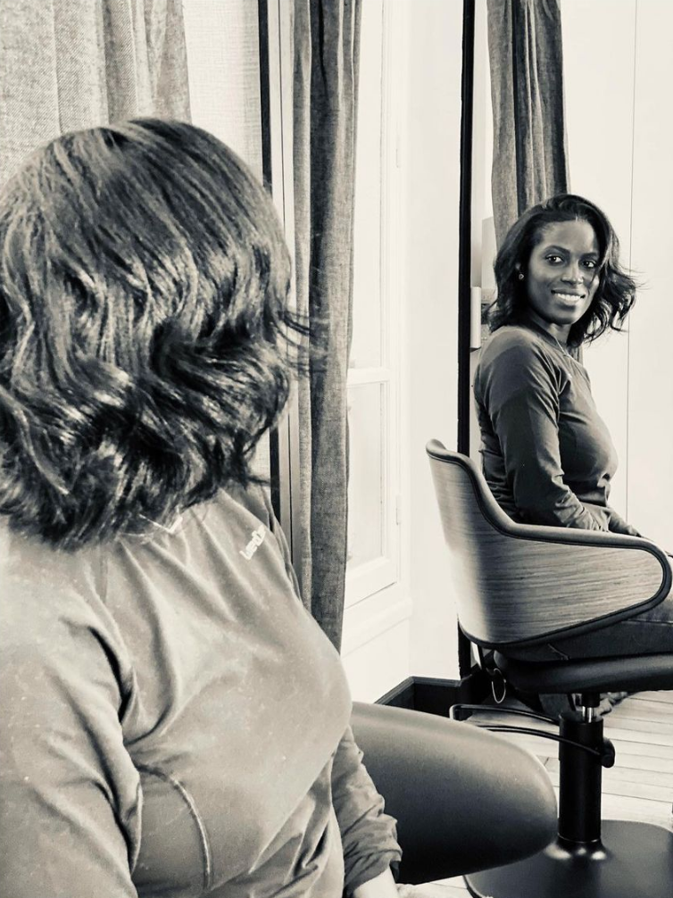 Une femme assise se regarde dans un miroir. 