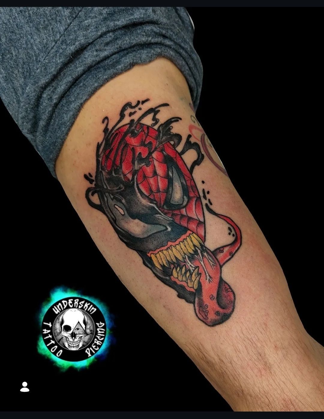 Tatuaggio spiderman Venom con dettagli rossi, neri sulla parte interna dell'avambraccio.