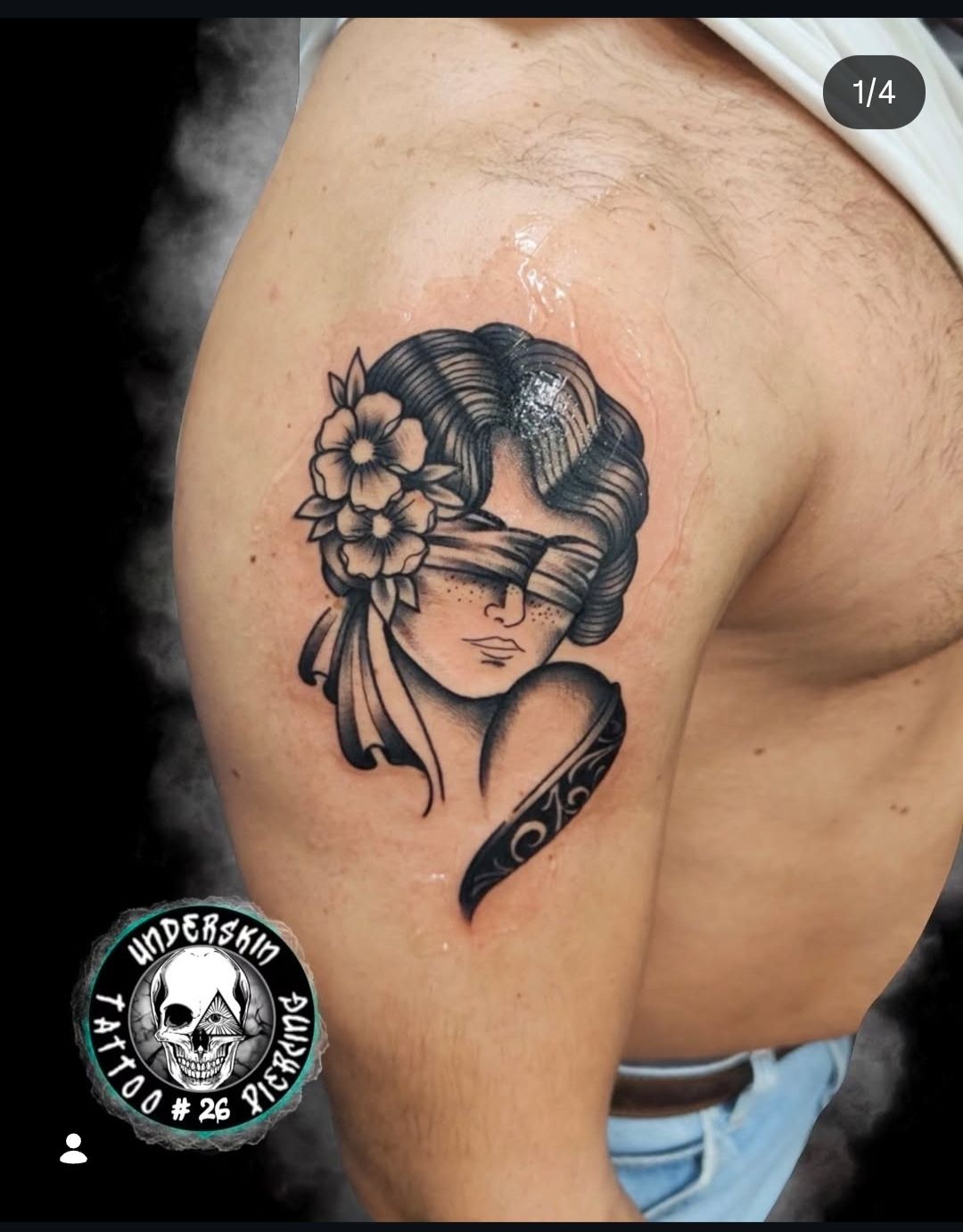 Tatuaggio nero sulla parte superiore del braccio, raffigurante il volto di una donna e un motivo paisley.