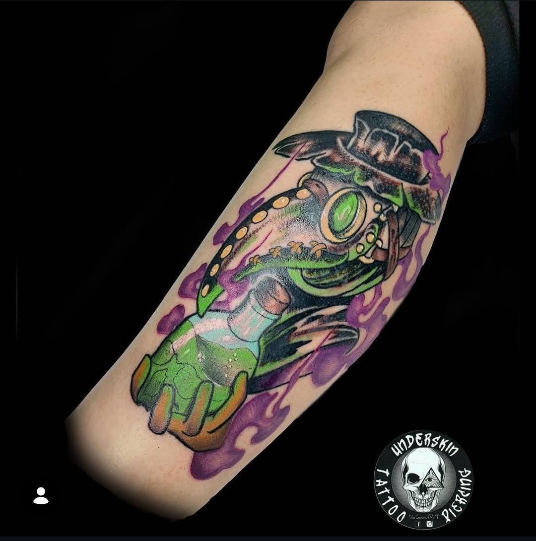 tatuaggio maschera da medico della peste con in mano una boccetta di pozione verde fosforescente e intorno una nebbia viola