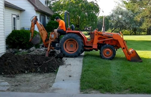 A backhoe is used to fill in gravel