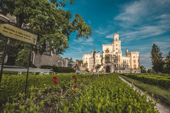 V pozadí je hrad a v popředí znak.