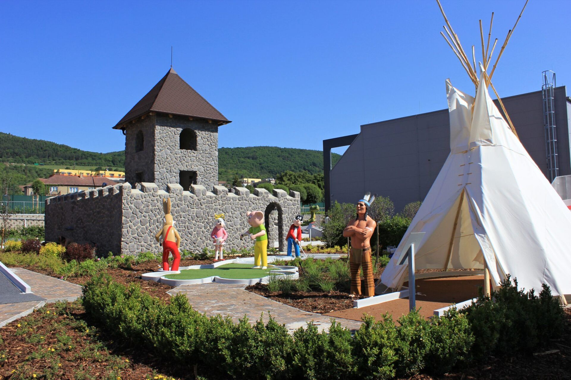 Před kamenným hradem sedí teepee