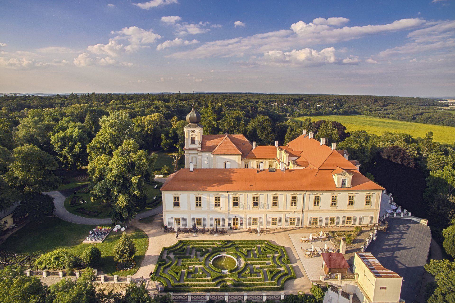Letecký pohled na velký hrad obklopený stromy.