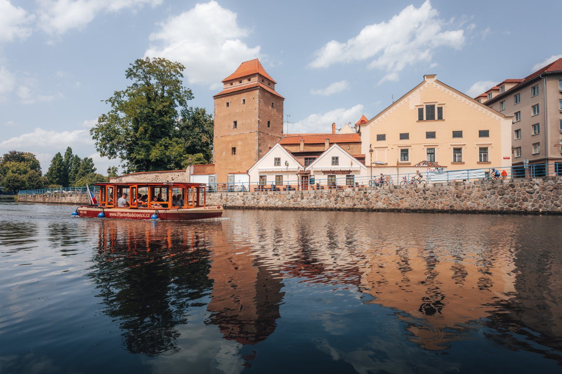 Loď pluje po řece před budovou.