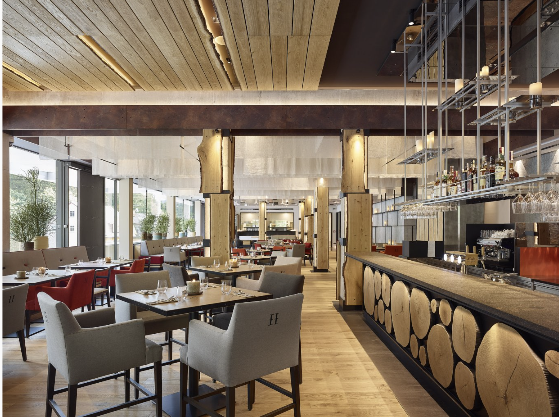 Velká restaurace se stoly a židlemi a barem.