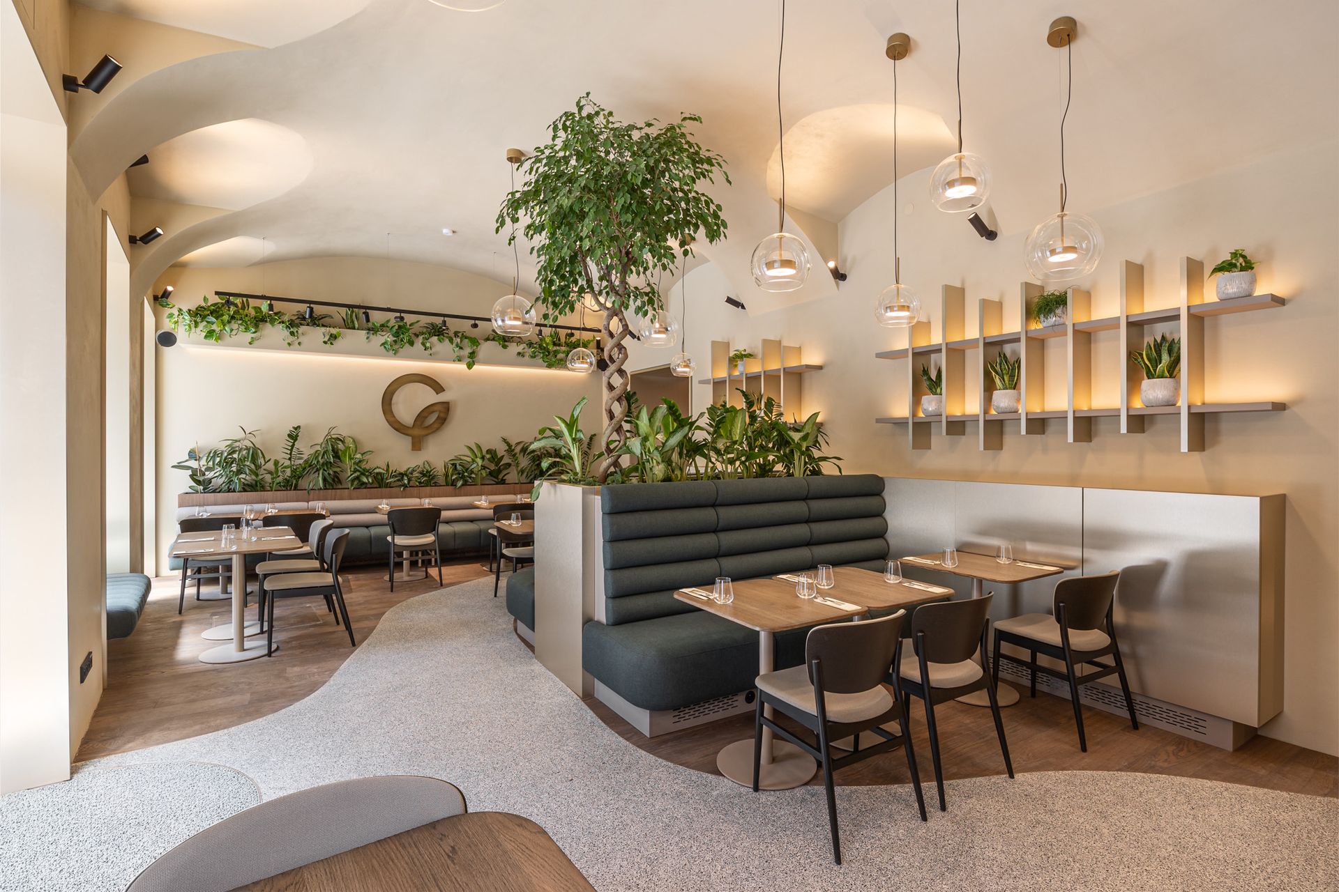 Restaurace se stoly a židlemi a dlouhým gaučem.