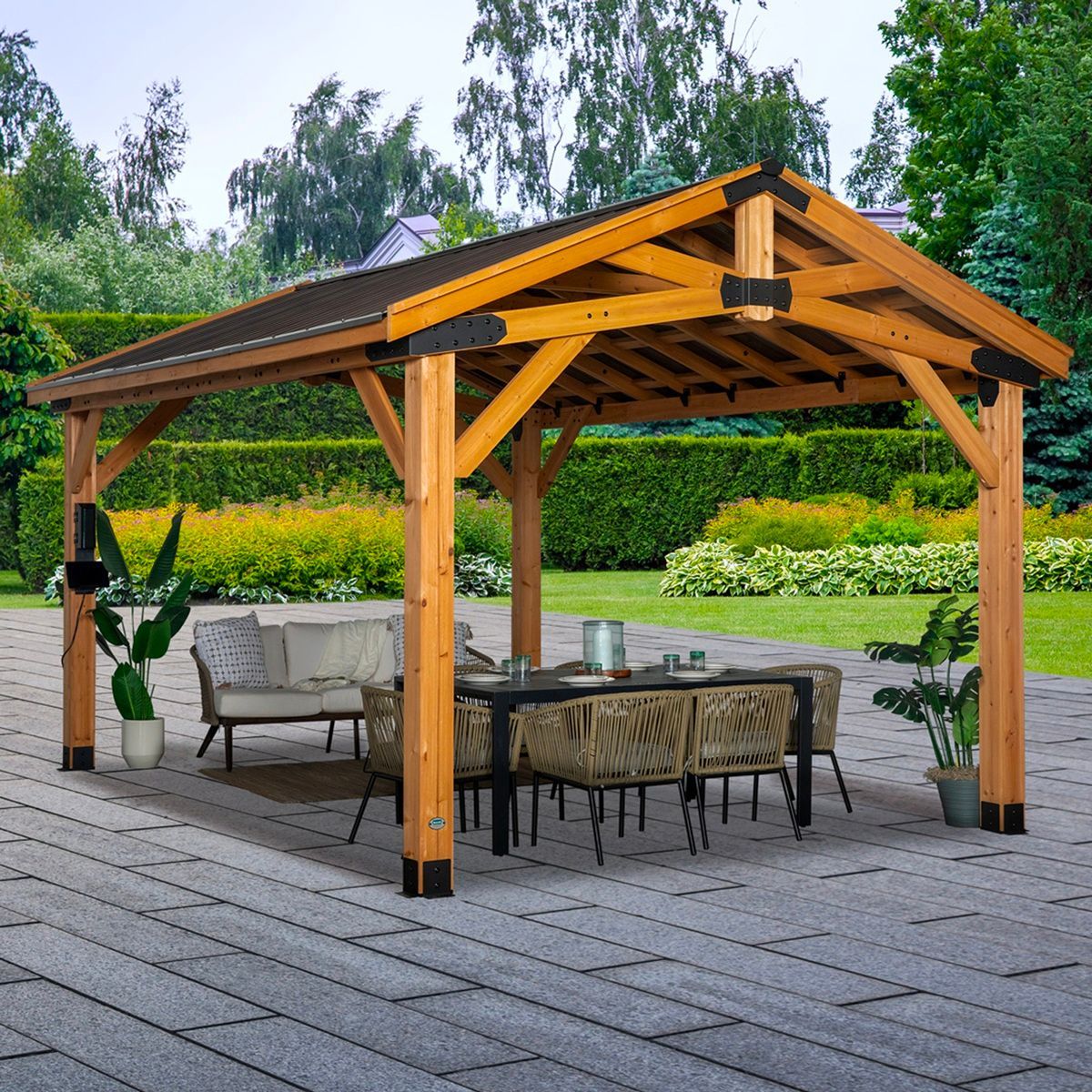 Wooden pavilion with patio seating on a stone terrace in a landscaped garden