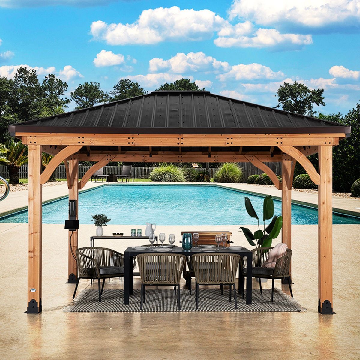 Wooden poolside gazebo with dining table and chairs beside a backyard swimming pool