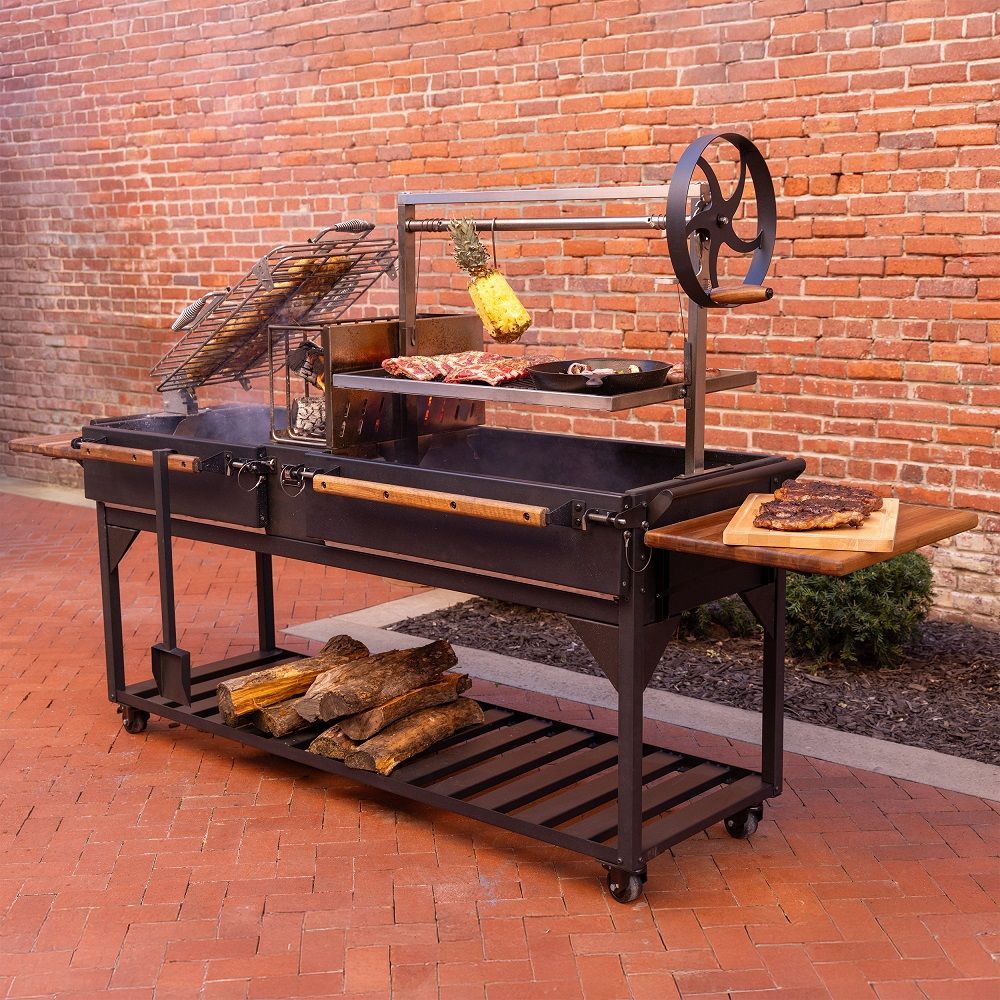 Outdoor rotisserie grill with a hanging roast, black metal frame, against a brick wall