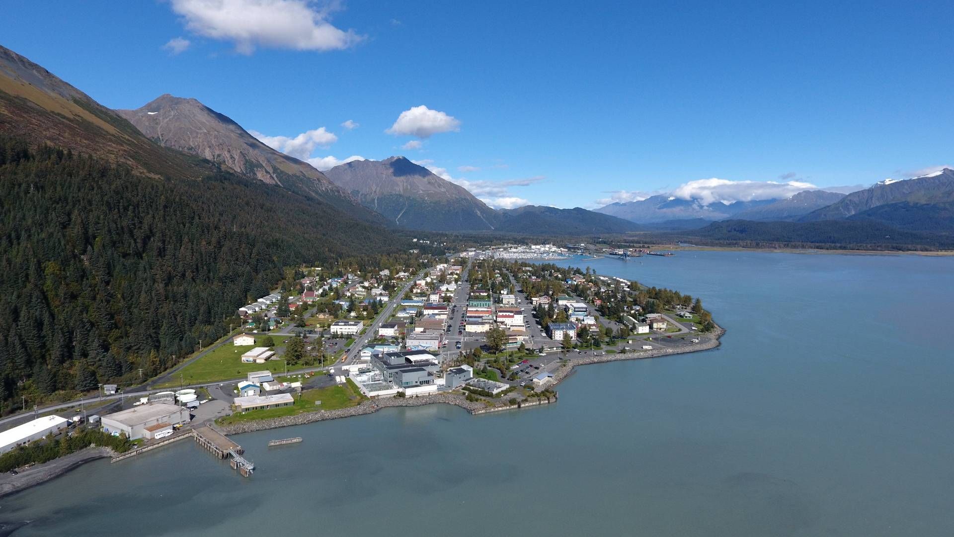 An aerial view of residential homes and businesses in Seward, Alaska, with gorgeous mountains and water