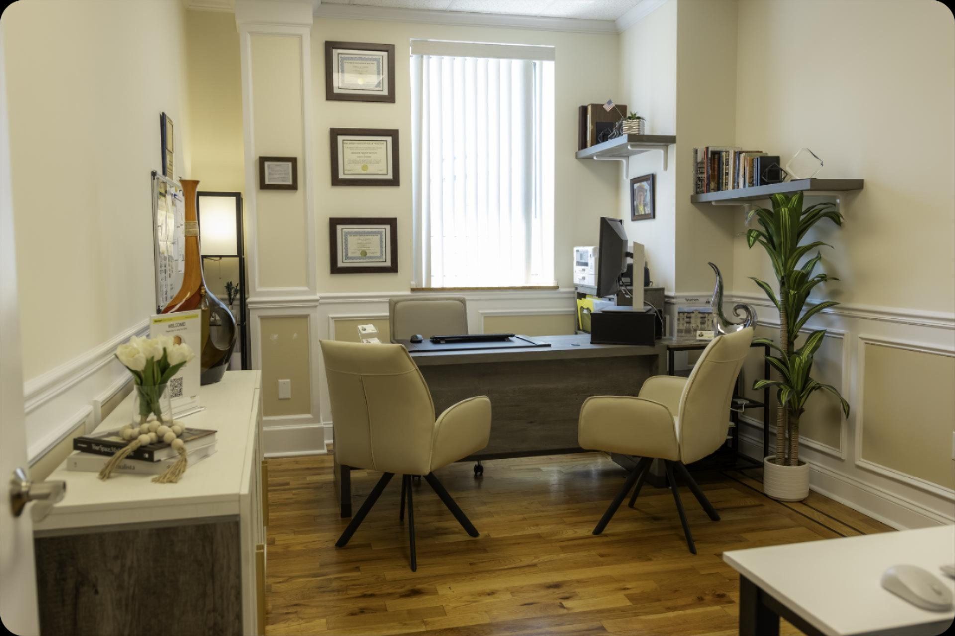 A small office with a desk , chairs and a computer.