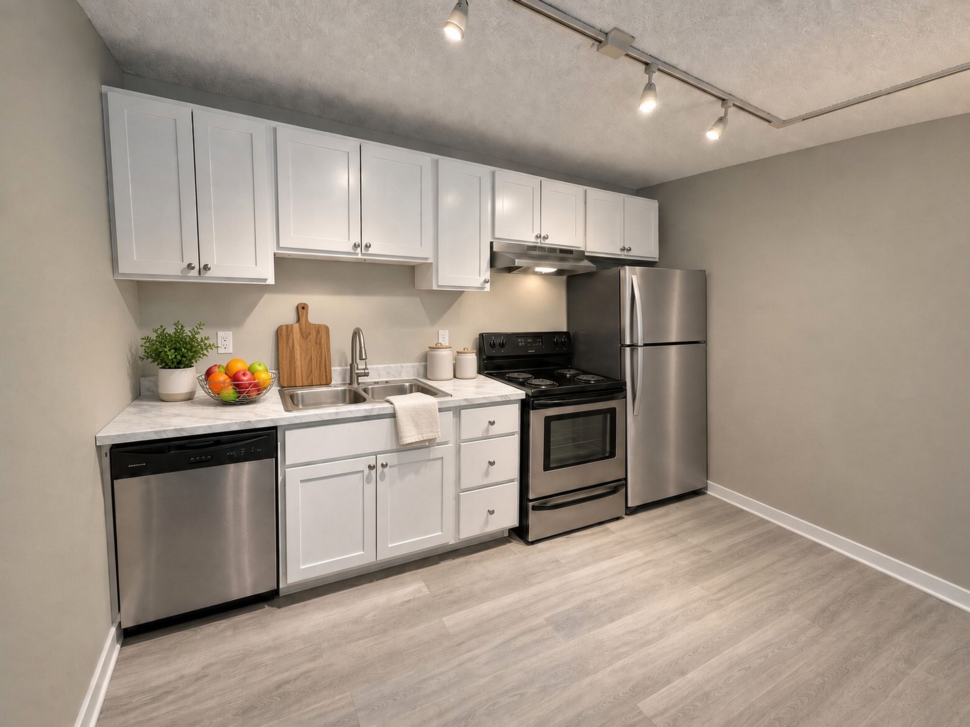 Renovated kitchen with white cabinets and stainless appliances at The Groves