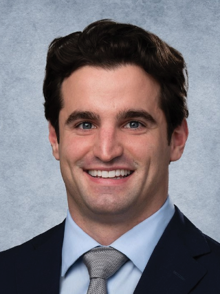 A man in a suit and tie is smiling for the camera