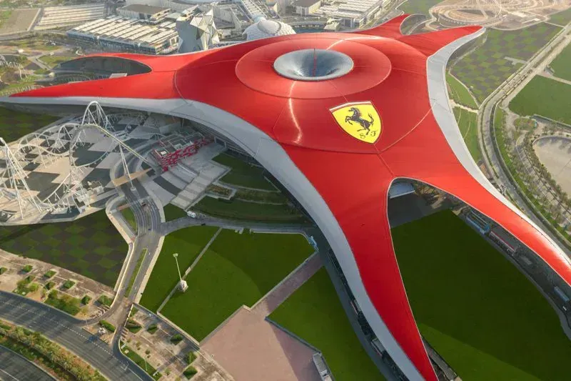An aerial view of a large red and white building with a ferrari logo on the top.