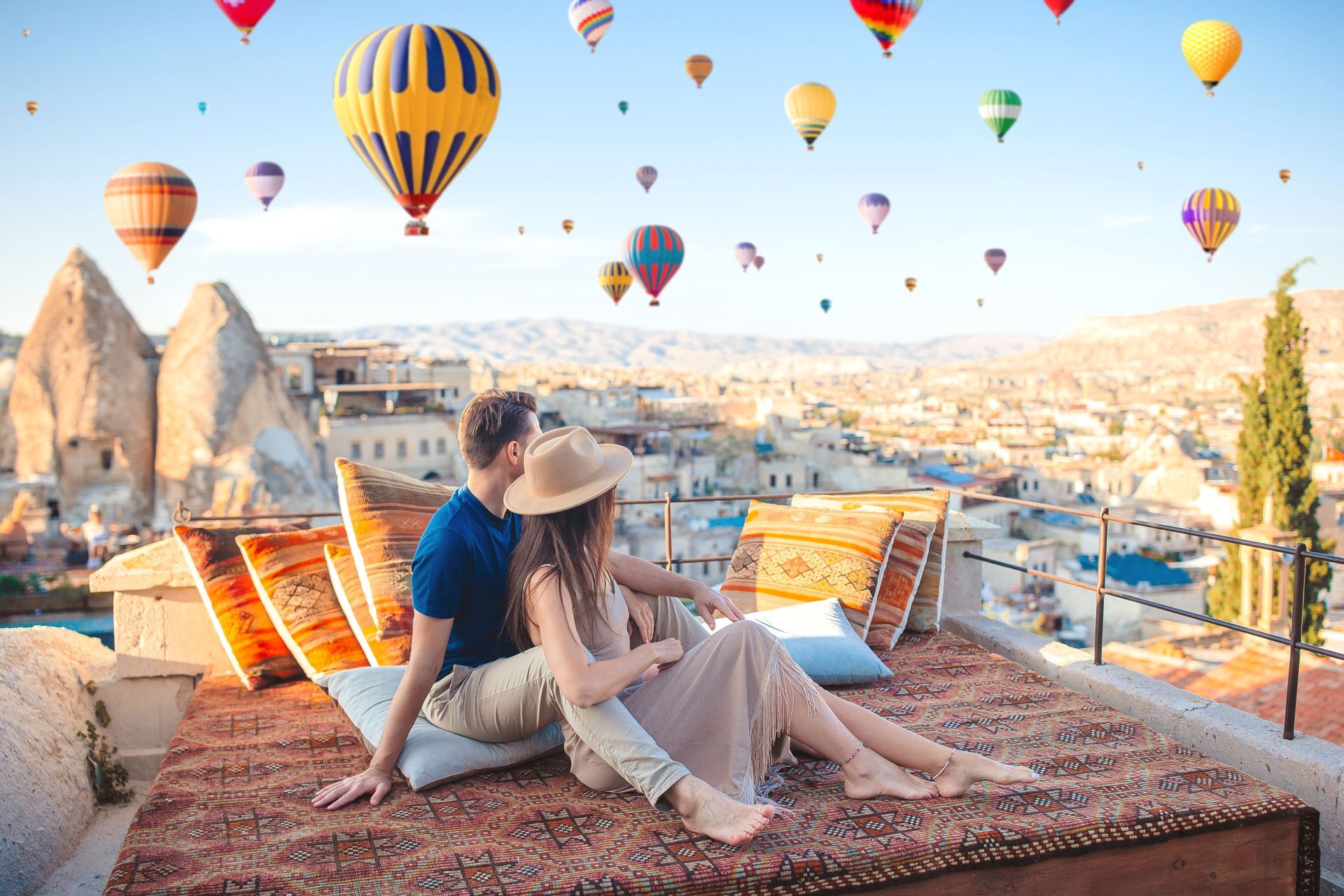Tourist couple enjoying the view of hot air balloons in the air in Turkey.