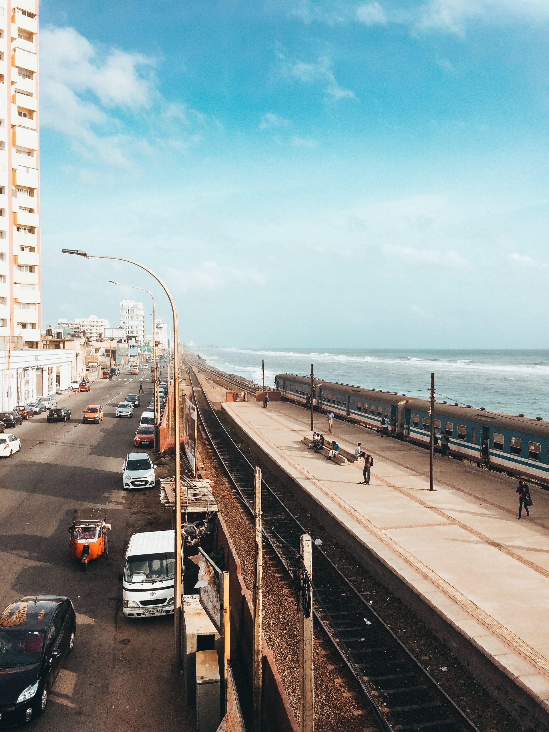 A train is pulling into a train station near the ocean