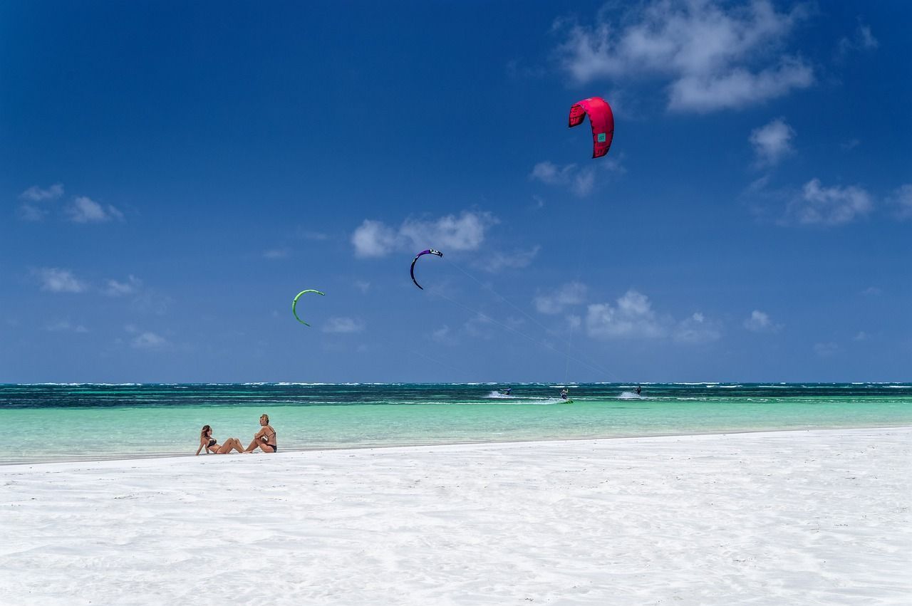 Tourists chilling and kitesurfing on a beach in Kenya.