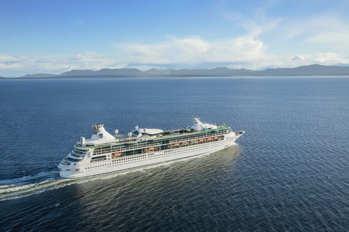 A large cruise ship is floating on top of a large body of water.